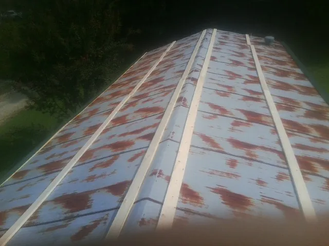 Rusted metal roof panels with new wood purlins before replacement — Storm Damage Roof Repair in Blue Ridge by Roofing Brothers